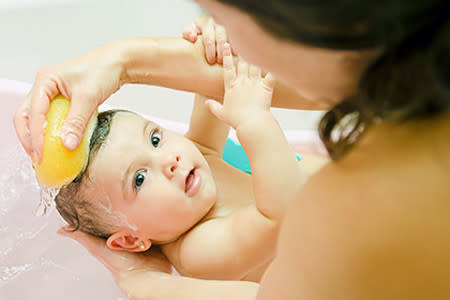 Mom bathing newborn