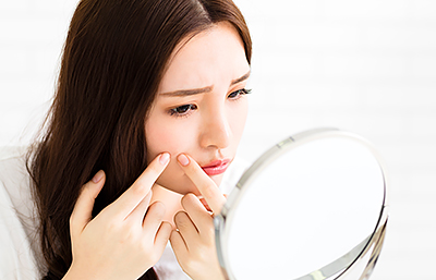 Woman popping pimple