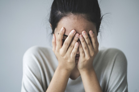 Girl covering her face with her hands