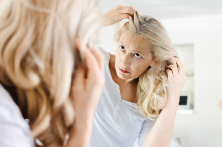 Woman in her 50s inspecting her hairline