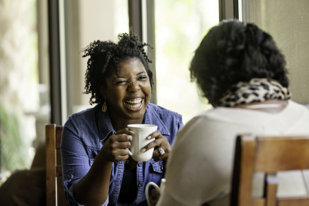 African American women having a good while drinking coffee