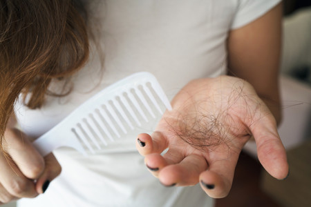 Woman looking at hair that came off when combing