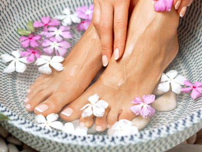 woman's feet in water bowl with flowers