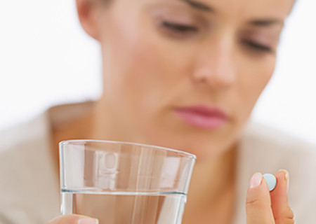 woman looking at pill