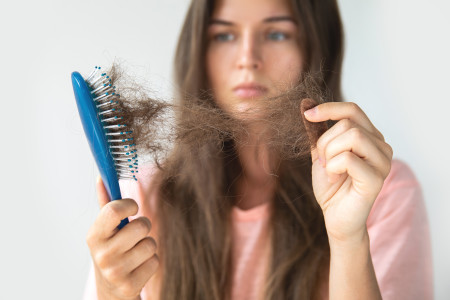 woman pulling hair from brush