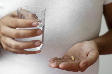 person with pill in hand