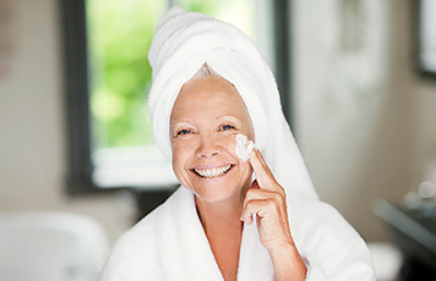 woman applying lotion to face