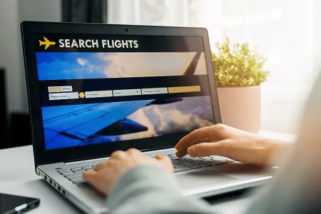 Person using laptop to search for flight reservations