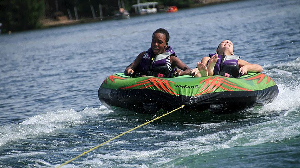 Children being pulled by a boat in an inner tube