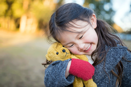 Happy girl outside on cold day, which can trigger eczema.