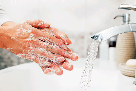 Washing hands at bathroom sink