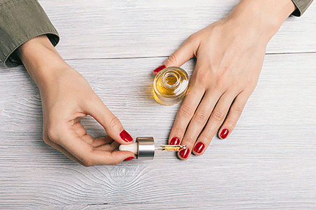 Woman applying cuticle oil