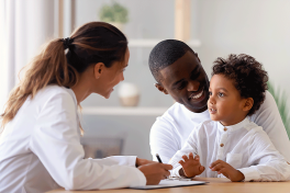 Female dermatologist with father and child patient