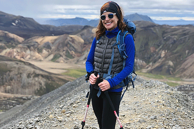 woman with hiking poles on a mountain trail