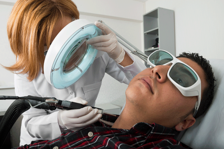 Man having hair removal with laser device neck area at the dermatologist doctors office.