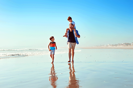 Father and his two little sons together at the beach