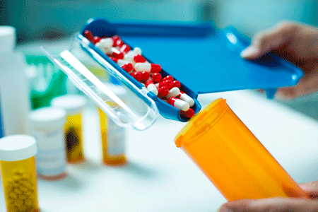 A pharmacist fulfilling a prescription pill bottle.