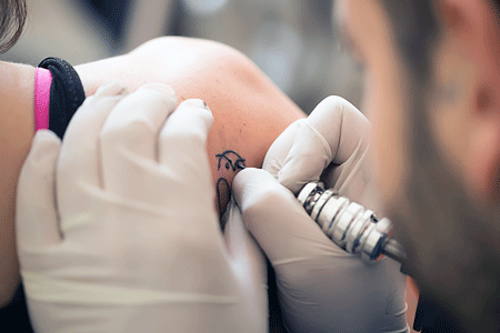 Woman getting a tattoo on her shoulder