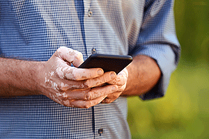 Close-up of man with vitiligo on hands using cell phone