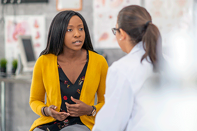 Young woman talking with her dermatologist