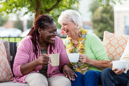 A senior woman laughing with her mature female friend.