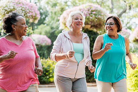 Three women over 50 years of age walking briskly.